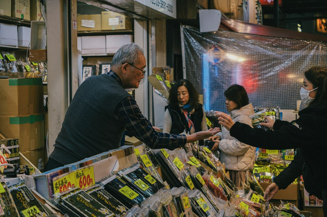 Japanese senior couple receiving a membership card from a smiling staff member